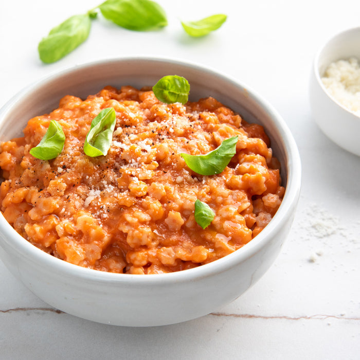 Gluten-free Jovial Brown Rice Stelline pasta with tomato sauce, showcasing the pasta's small, star-shaped shape and cooked texture.