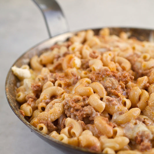 Jovial Gluten Free Brown Rice Elbows pasta in a clear bowl, showcasing its short, curved shape and brown rice texture.