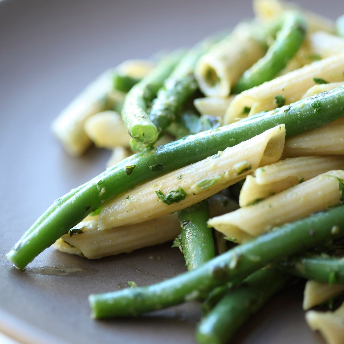 Jovial Gluten Free Brown Rice Penne Rigate pasta in a serving bowl, showcasing the pasta's shape and texture.