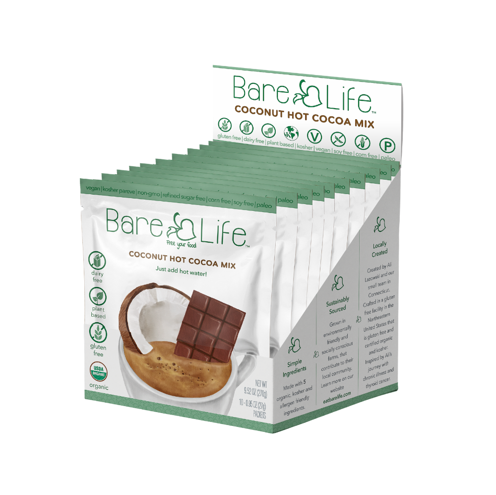 Bare Life dairy-free coconut hot cocoa mix single serving packets, showing the packaging and cocoa mix inside.