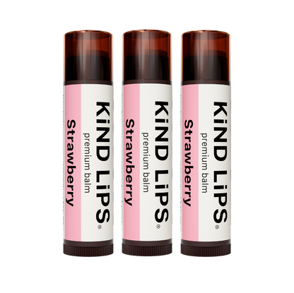 Organic strawberry lip balm by Kind Lips, showing a natural tube with pink packaging and a fresh strawberry flavor label.