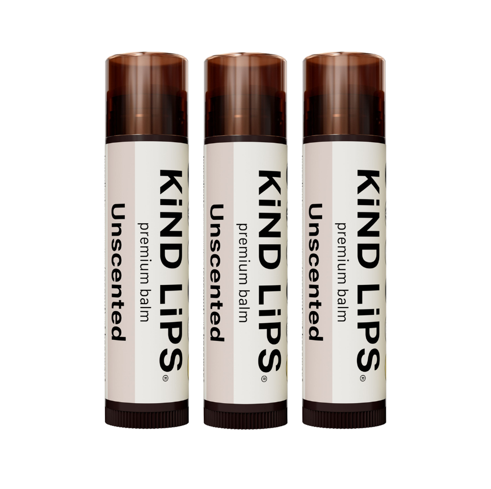 Kind Lips Unscented Organic Lip Balm in a small container with a white lid, displayed on a neutral background.
