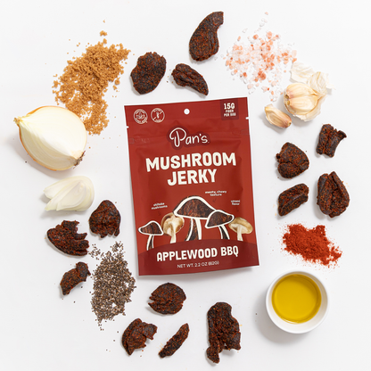 Pan's Mushroom Jerky Applewood BBQ Mushroom Jerky with smoky, savory flavor and tender texture, displayed on a wooden surface