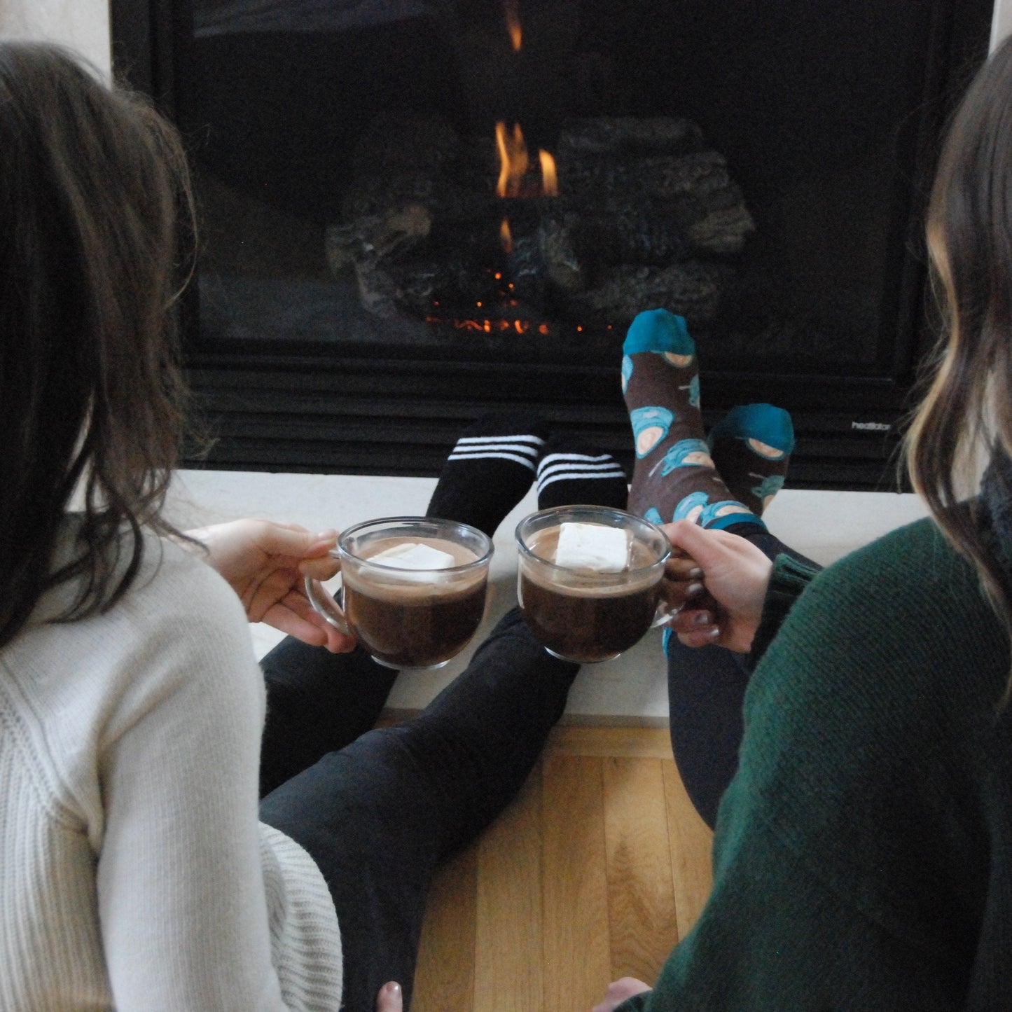 Bare Life dairy-free coconut hot cocoa mix in a mug topped with marshmallows, set in front of a holiday fire.