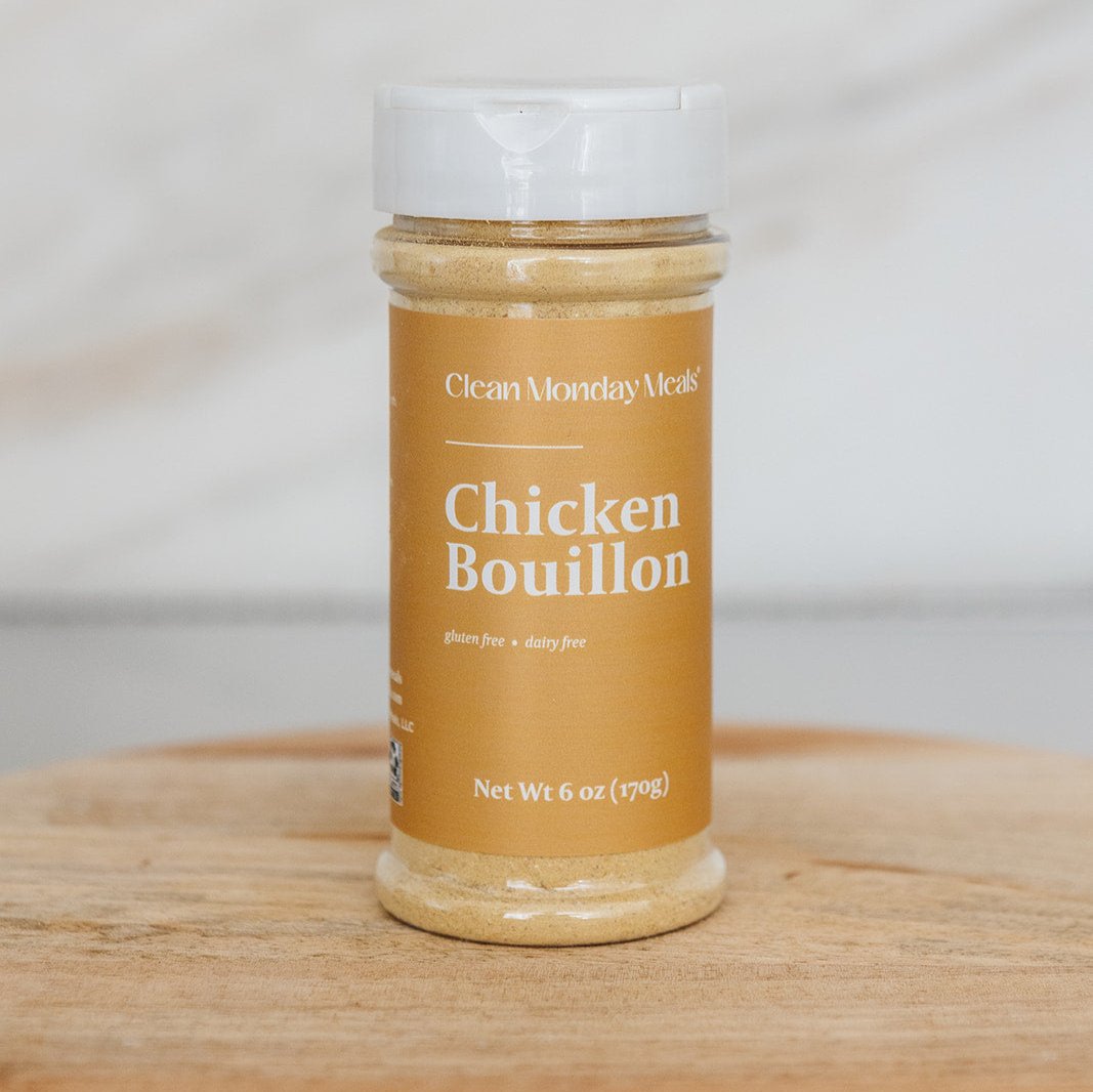 Clean Monday Meals Chicken Bouillon seasoning in a jar, with a close-up view of the label and seasoning granules inside.
