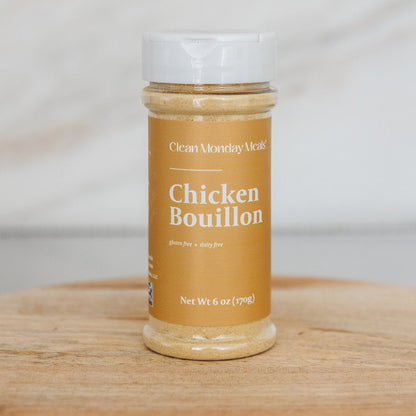 Clean Monday Meals Chicken Bouillon seasoning in a jar, with a close-up view of the label and seasoning granules inside.
