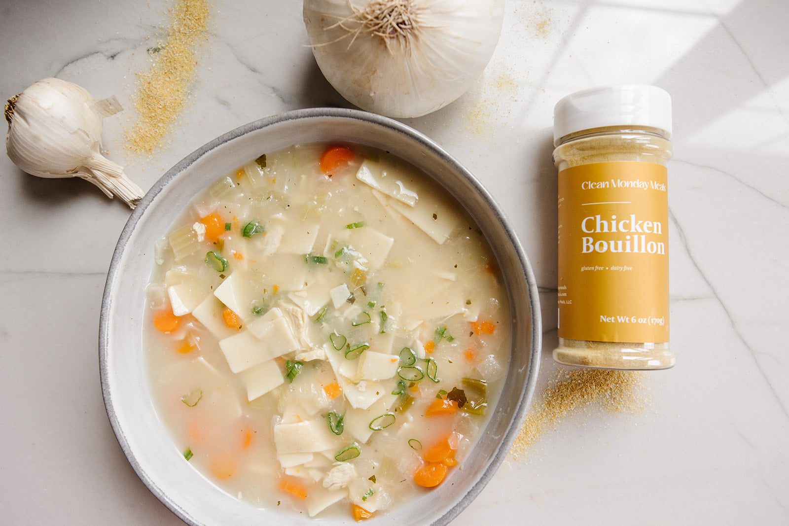 Clean Monday Meals chicken bouillon seasoning in a jar, with label visible, used for enhancing soups and stews.