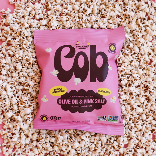 Cob Foods Pink Salt Popped Sorghum, gluten-free snack with pink salt flavor and olive oil, in a colorful bowl.