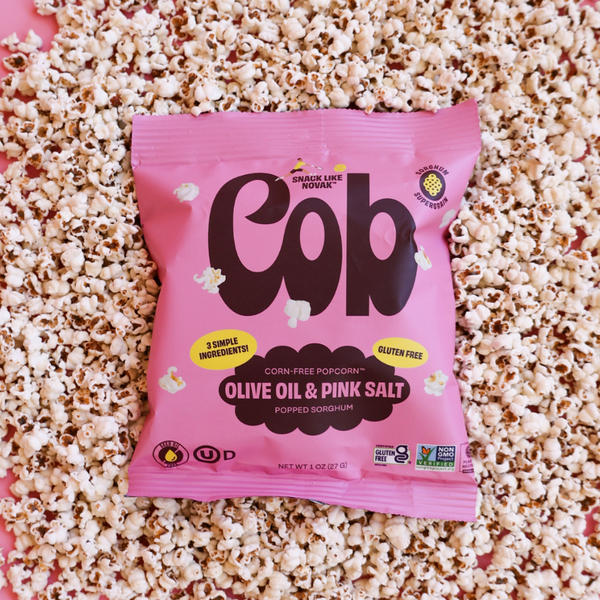 Cob Foods Pink Salt Popped Sorghum, gluten-free snack with pink salt flavor and olive oil, in a colorful bowl.