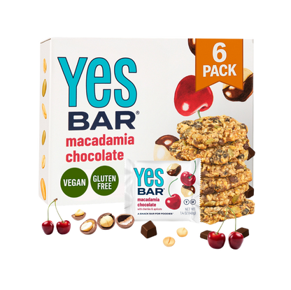 YES BAR Macadamia Chocolate energy bars, six-pack, showing chocolate-coated bars with macadamia nuts inside.