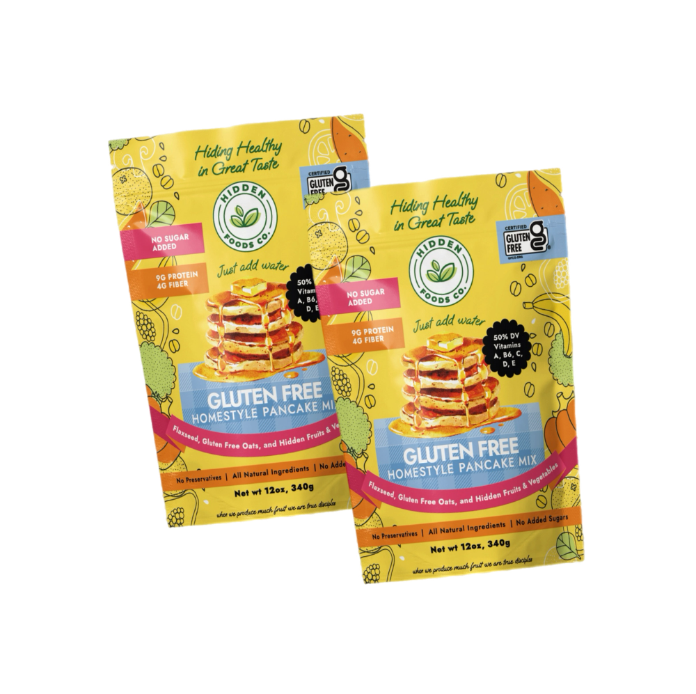 Gluten-free homestyle pancake mix 2-pack from Hidden Foods Co., showing fluffy cooked pancakes with syrup and butter on a plate.