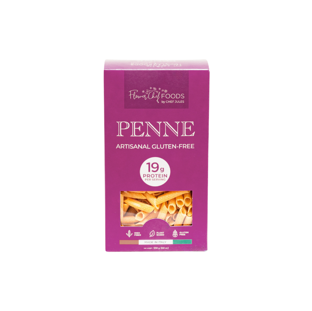 High protein Flower Chef Foods penne pasta in a clear bowl, showcasing the textured, uncooked pasta with a golden color.
