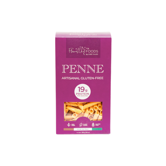 High protein Flower Chef Foods penne pasta in a clear bowl, showcasing the textured, uncooked pasta with a golden color.
