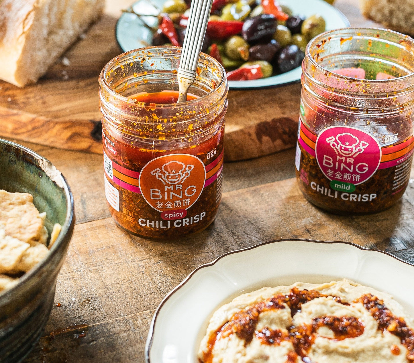 Two 7oz jars of Mr Bing Chili Crisp by Mr Bing Foods, showcasing vibrant red chili oil and crispy chili flakes.