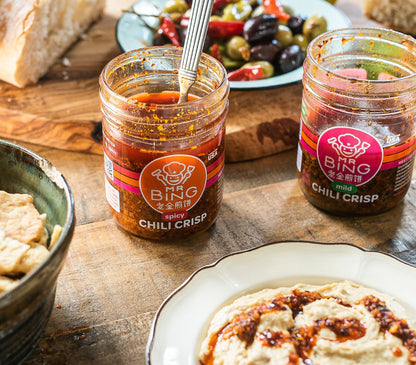 Two 7oz jars of Mr Bing Chili Crisp by Mr Bing Foods, showcasing vibrant red chili oil and crispy chili flakes.