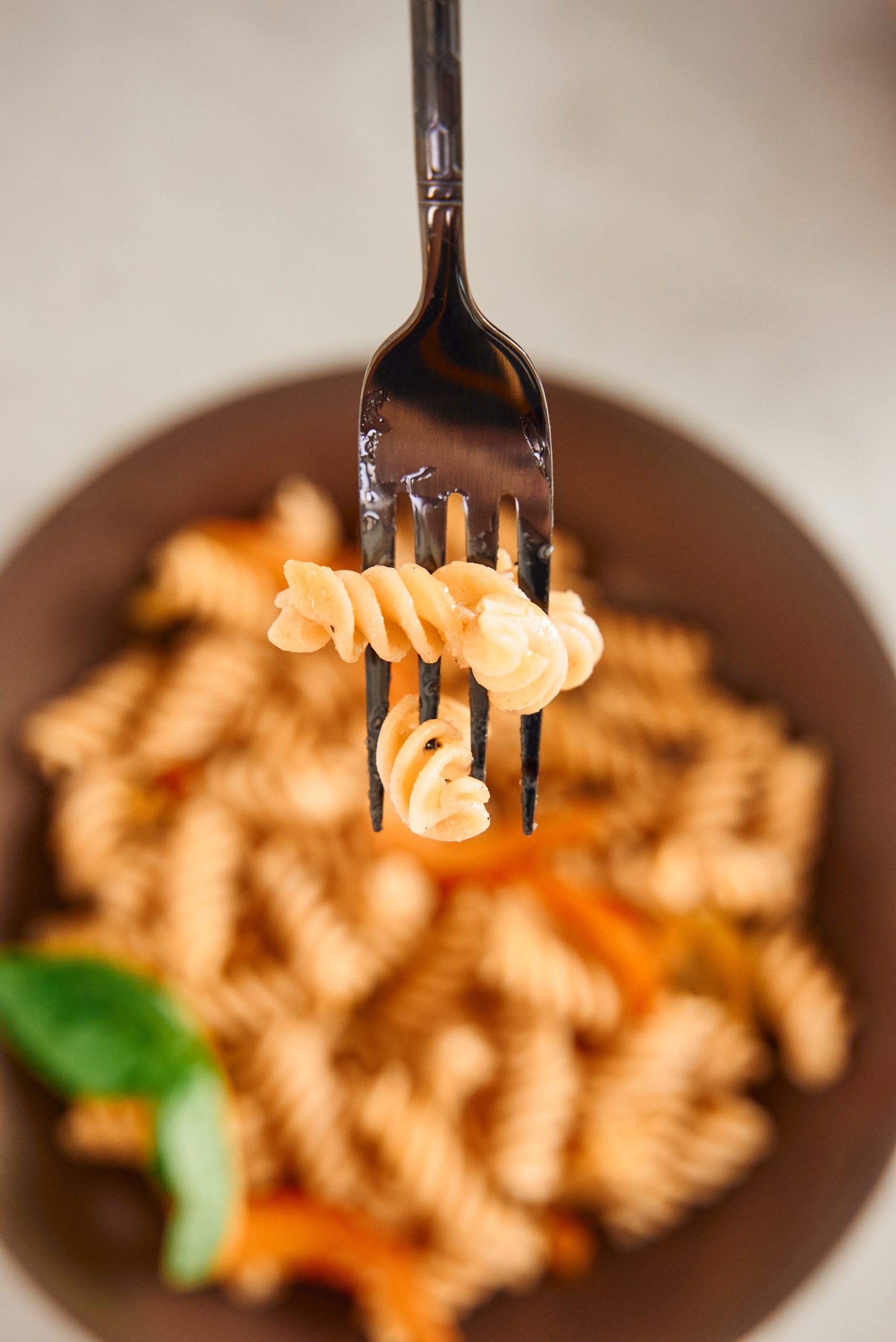 High-protein Flower Chef Foods Fusilli pasta in a clear bowl, showing spiral-shaped pasta on a white background.