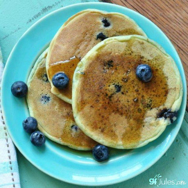 Gluten-free gfJules pancake and waffle mix package with a bowl of prepared pancakes and waffles on a plate.