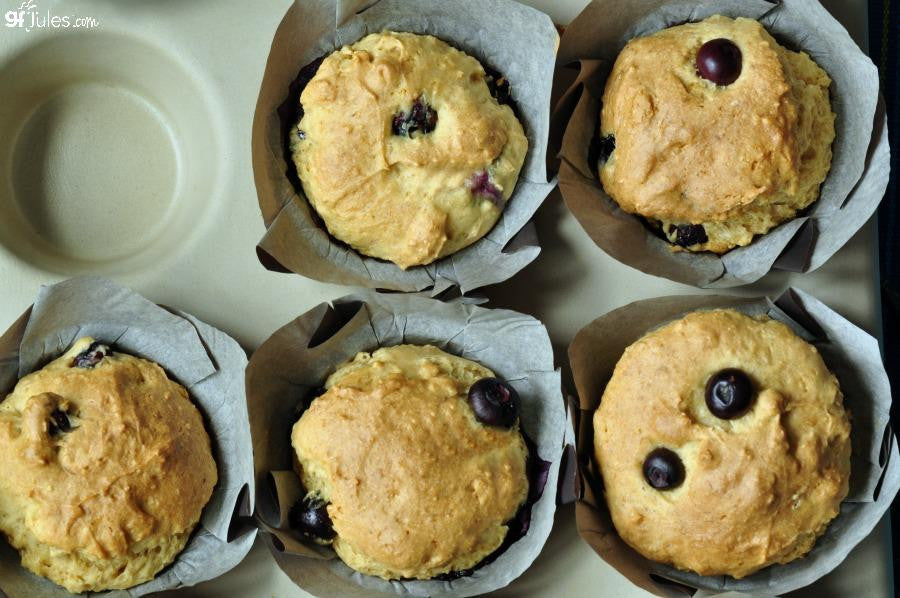 Gluten-free muffin mix by gfJules, showing a bowl of prepared batter with baking ingredients and mixing utensils.