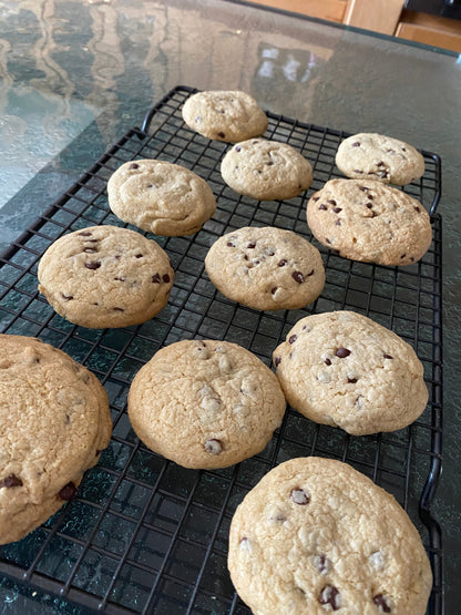 gfJules gluten-free cookie mix in a clear bowl, showing freshly baked cookies with chocolate chips and a rustic wooden background.