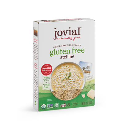 Jovial Gluten Free Brown Rice Stelline pasta in a white bowl, showing small, star-shaped pasta pieces on a neutral background.