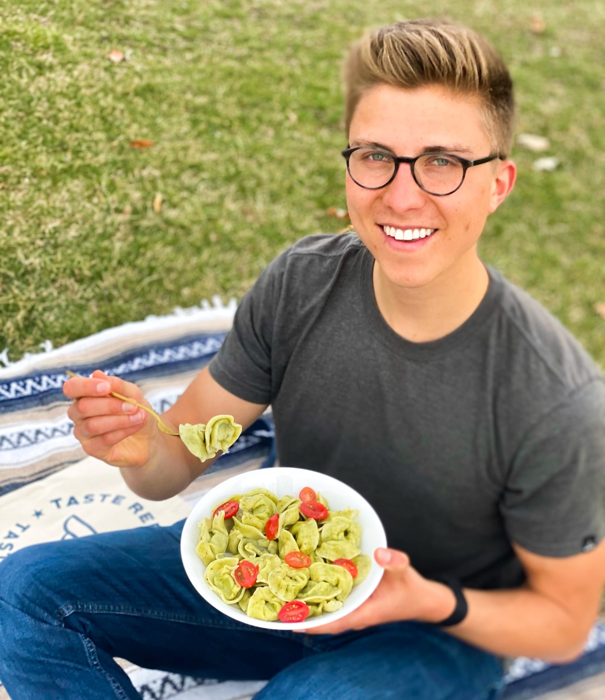 Nolan eating Taste Republic gluten-free spinach and cheese tortelloni pasta, showing the fresh, stuffed pasta on a plate.