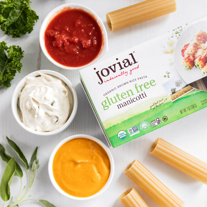 Pumpkin and sage stuffed gluten-free brown rice manicotti by Jovial Foods, Inc., served on a white plate with herbs.