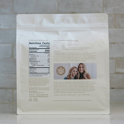 Pack of Clean Monday Meals ramen noodles with a daughter holding a bag of ramen on a kitchen counter.