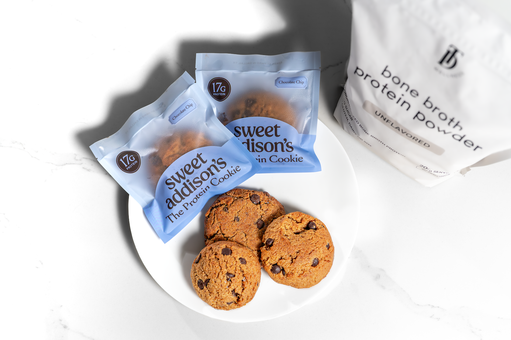 Sweet Addison's protein cookie with 17g of protein, showing a freshly baked, chocolate chip cookie on a white plate.