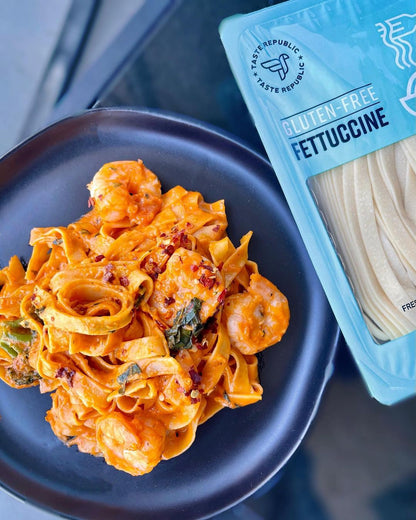 Fresh gluten-free fettuccine pasta by Taste Republic, cooked and plated with sauce, ready to serve on a dinner plate.