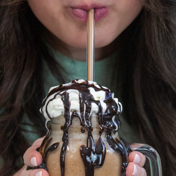 Vegan gluten-free frozen hot cocoa mix by Bare Life, featuring a hot chocolate drink in a glass with cocoa powder and whipped topping.