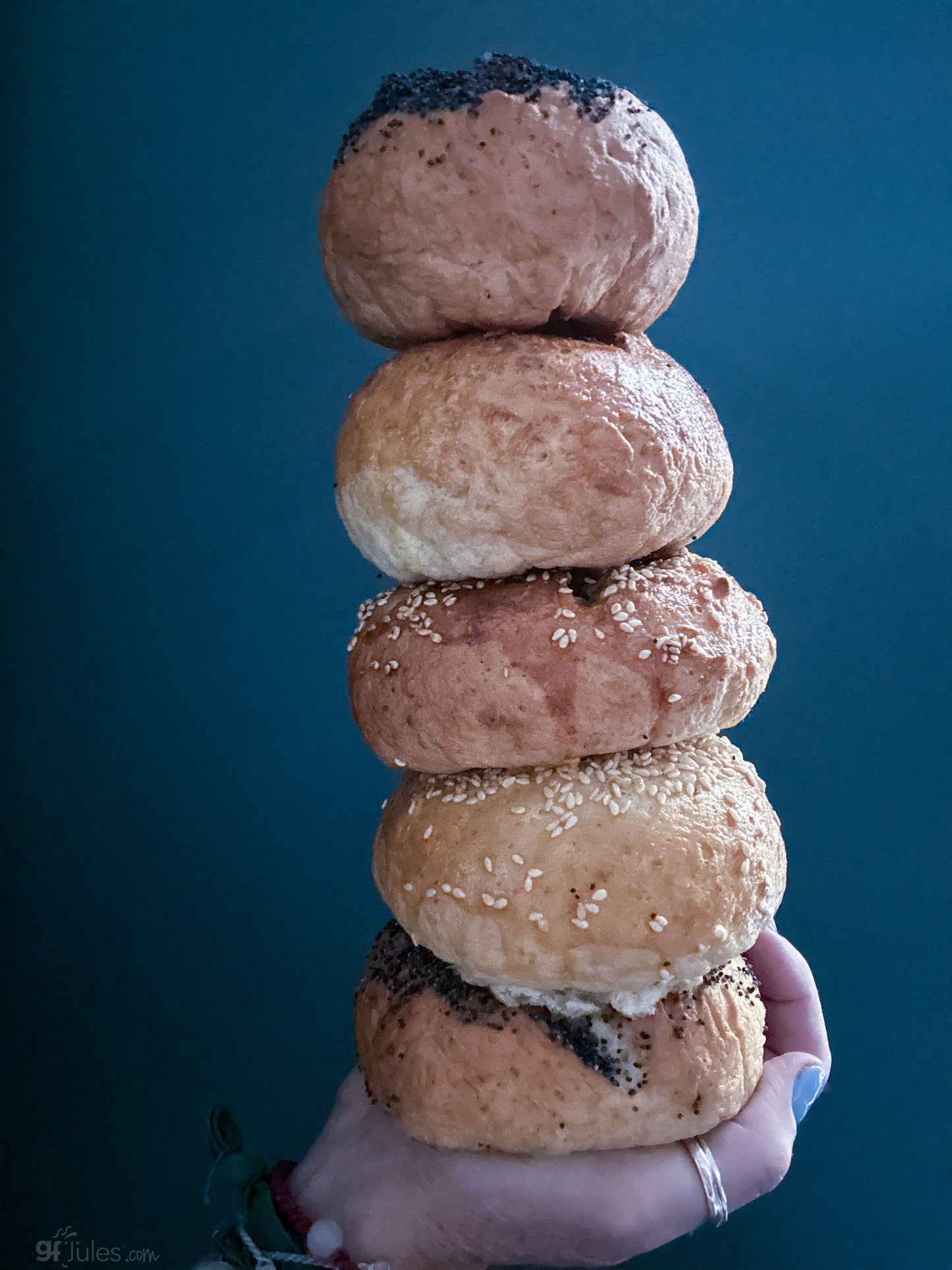 Stack of gfJules gluten-free bagels made from the gfJules gluten free bread mix, showing golden-brown, sliced bagels on a wooden surface.