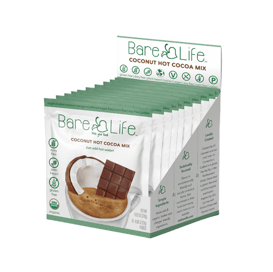 Bare Life dairy-free coconut hot cocoa mix single serving packets, showing the packaging and cocoa mix inside.
