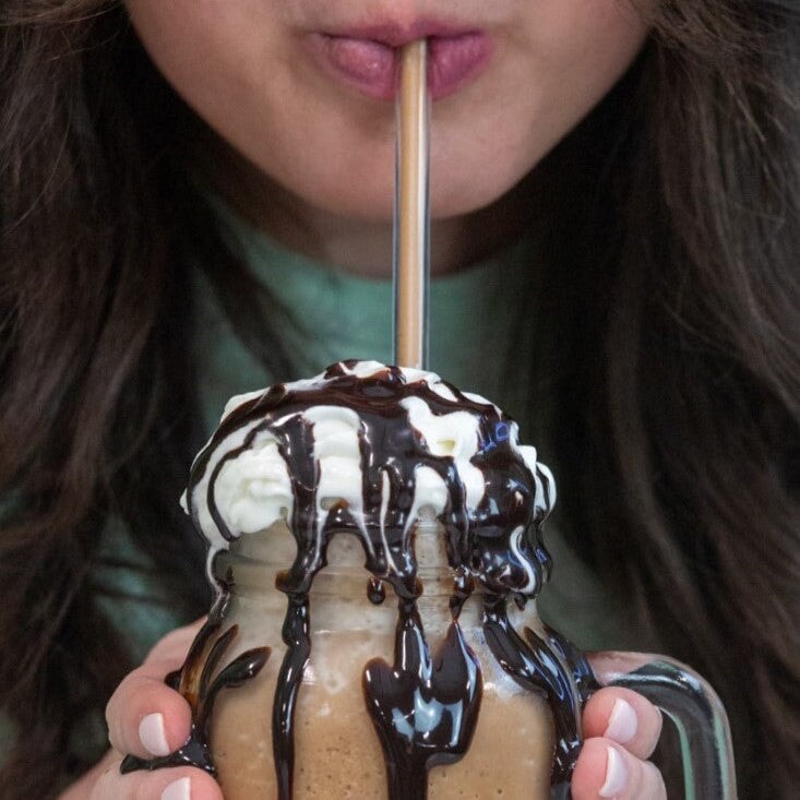 Vegan gluten-free frozen hot cocoa mix by Bare Life, featuring a hot chocolate drink in a glass with cocoa powder and whipped topping.