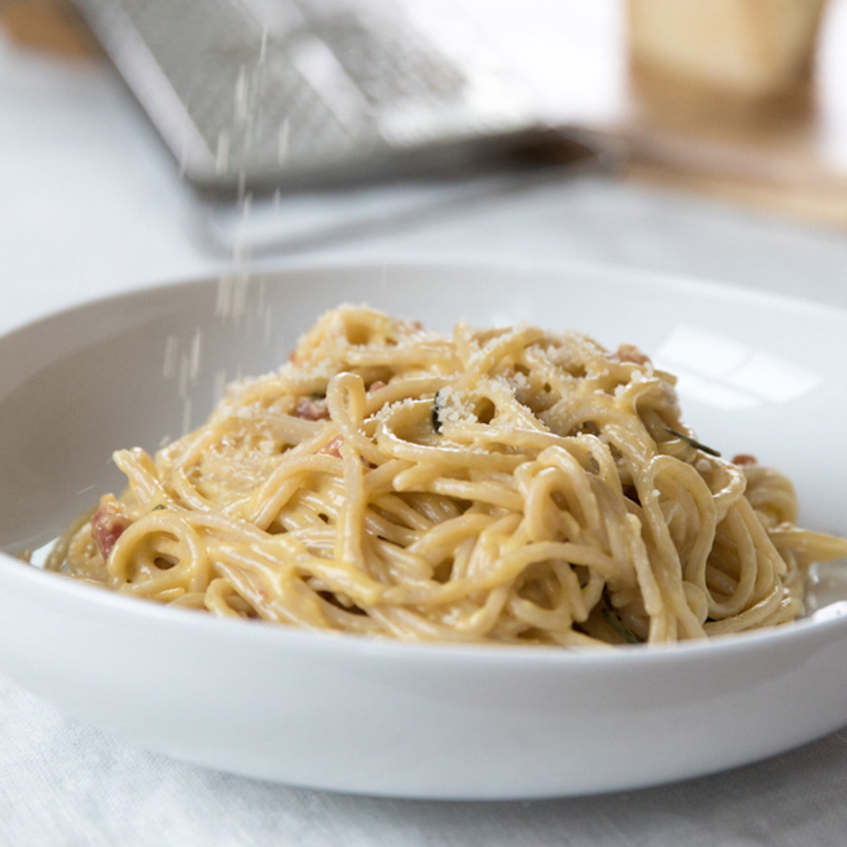 Jovial Gluten Free Brown Rice Spaghetti cooked and served with rosemary and carbonara sauce on a plate.