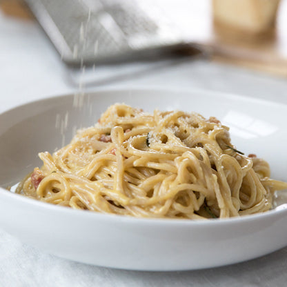 Jovial Gluten Free Brown Rice Spaghetti cooked and served with rosemary and carbonara sauce on a plate.