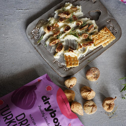 Three dried Turkish figs from drybox, showcasing their wrinkled texture and rich brown color in a close-up image.