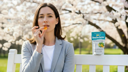 Woman holding a herbal lozenge from Essential Candy Breathe Better™ in a garden, showcasing the botanical supplement for clearer breathing.