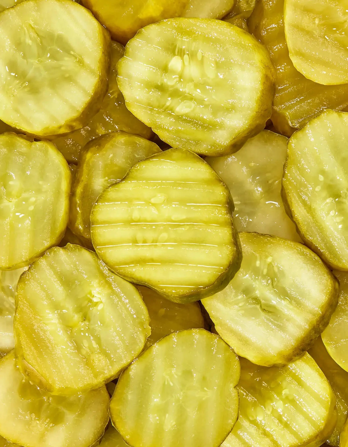 Freestyle Snacks Kickin' Picks Pickle Chips in a bowl, showing crispy pickle slices with a spicy seasoning on a white background.