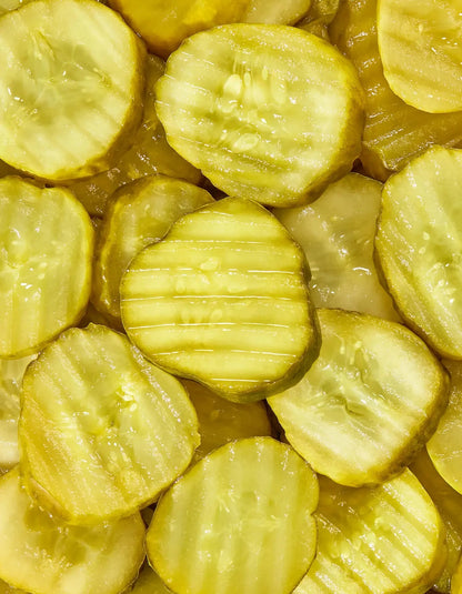 Freestyle Snacks Kickin' Picks Pickle Chips in a bowl, showing crispy pickle slices with a spicy seasoning on a white background.