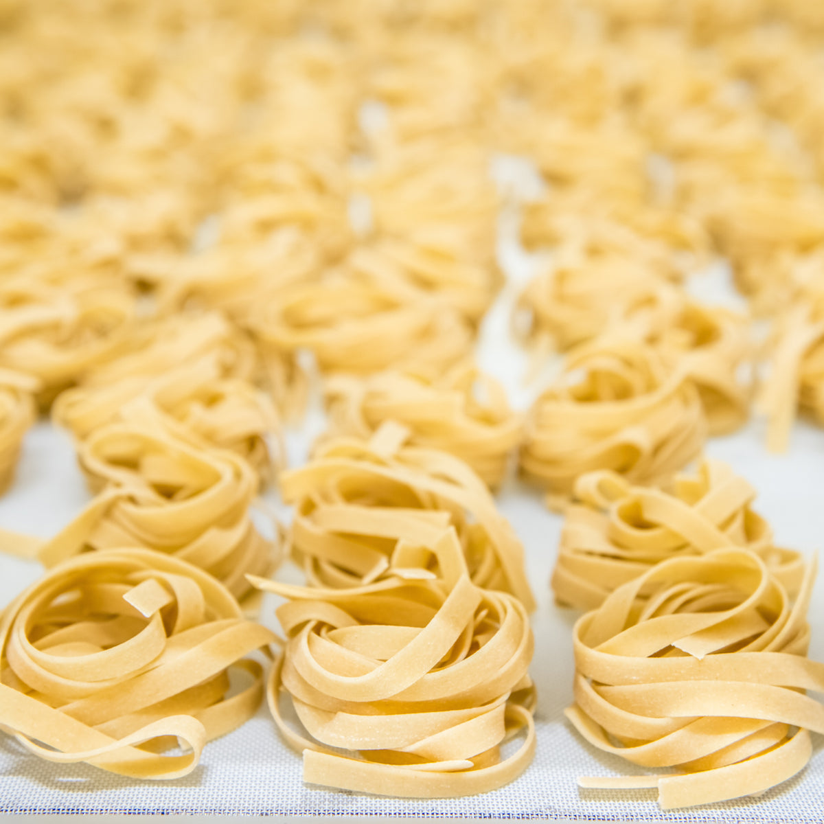 Jovial gluten-free brown rice pasta egg tagliatelle on a plate, showcasing the pasta's texture and golden color.