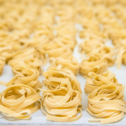 Jovial gluten-free brown rice pasta egg tagliatelle on a plate, showcasing the pasta's texture and golden color.