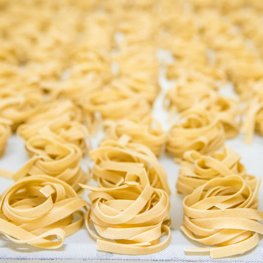 Jovial gluten-free brown rice pasta egg tagliatelle on a plate, showcasing the pasta's texture and golden color.