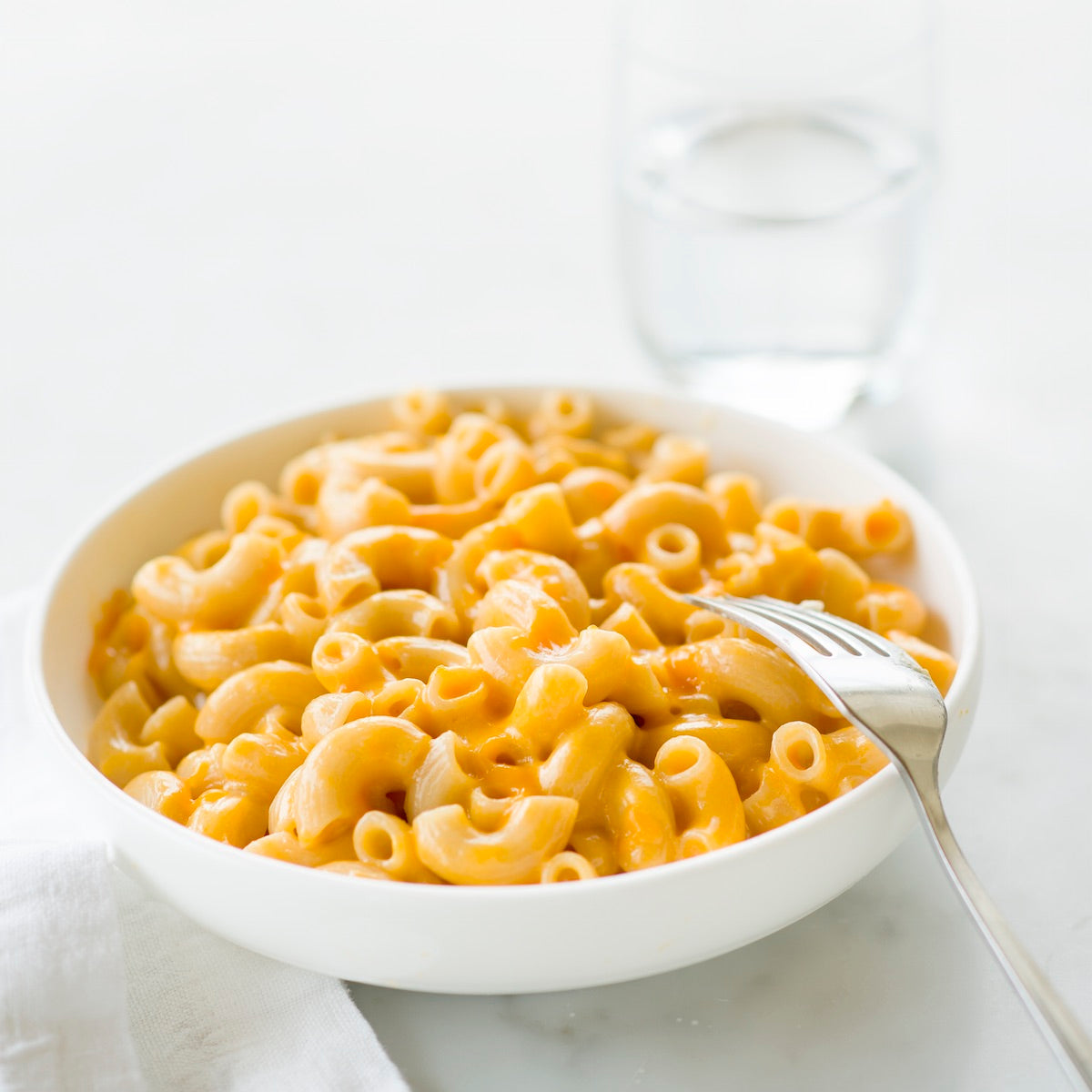 Jovial Gluten-Free Brown Rice Elbows pasta in a clear bowl, showing the short, curved brown rice pasta shape.