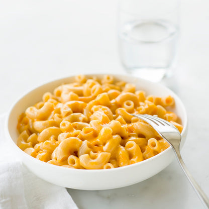 Jovial Gluten-Free Brown Rice Elbows pasta in a clear bowl, showing the short, curved brown rice pasta shape.