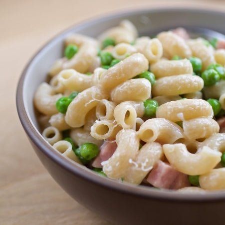 Jovial Gluten-Free Brown Rice Elbows pasta in a clear bowl, showing the short, curved brown rice pasta noodles.
