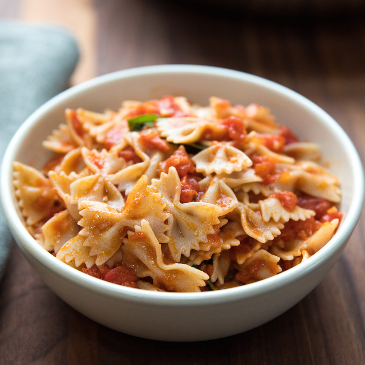 Jovial gluten-free brown rice farfalle pasta with marinara sauce in a bowl, showcasing the pasta's shape and rich tomato sauce.