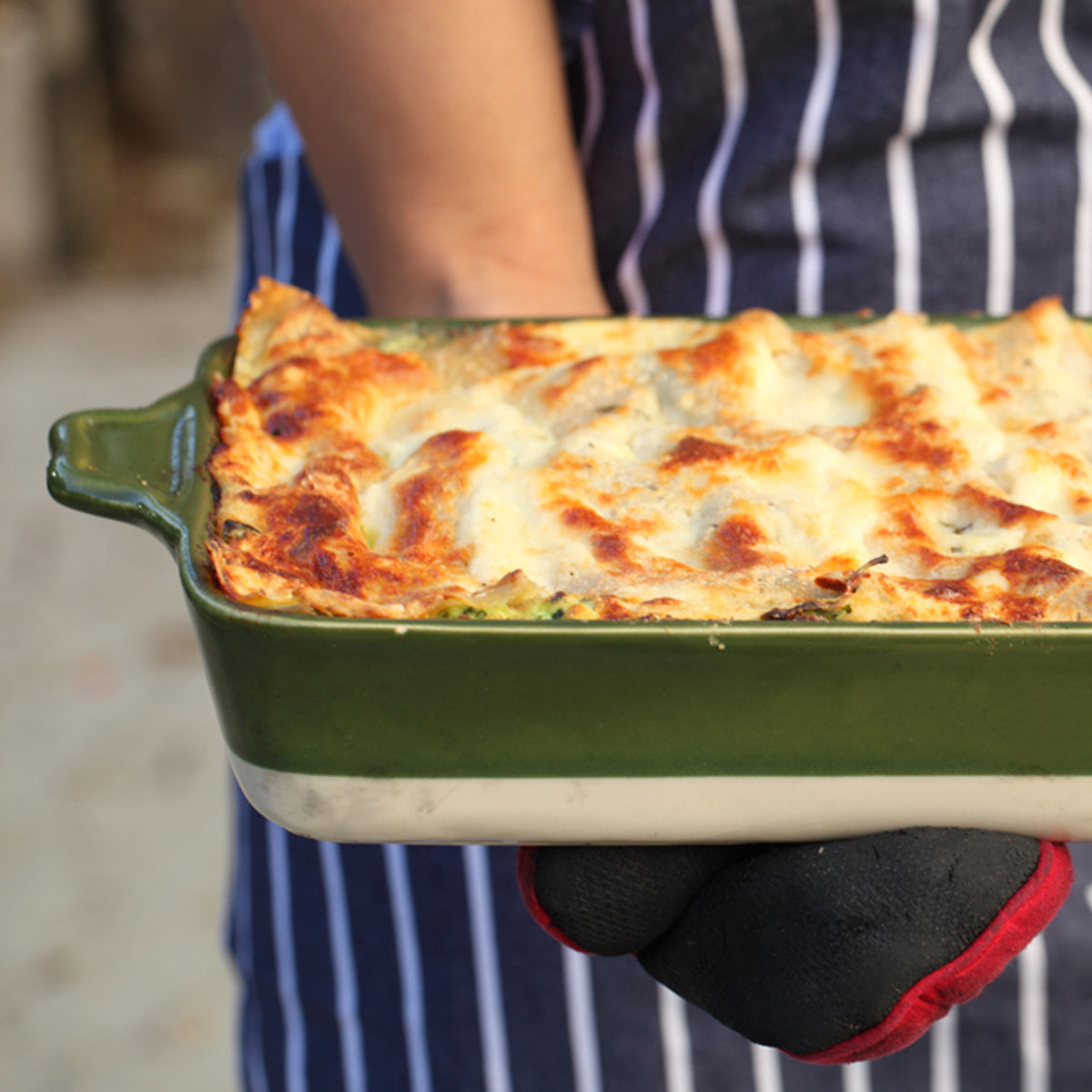 Gluten-free Jovial brown rice lasagna with visible layers of vegetables and melted cheese in a baking dish.