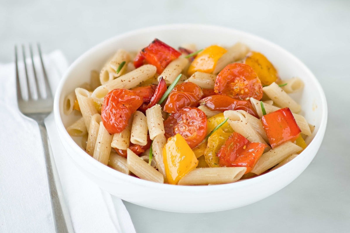 Single serving of Jovial gluten-free brown rice penne pasta with roasted peppers and tomatoes on a plate.