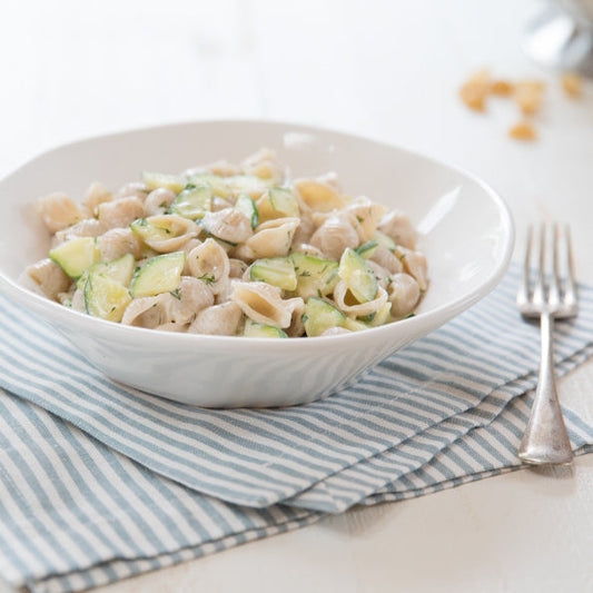 Gluten-free brown rice shells pasta by Jovial Foods, Inc, showing uncooked brown rice shell-shaped pasta on a white background.