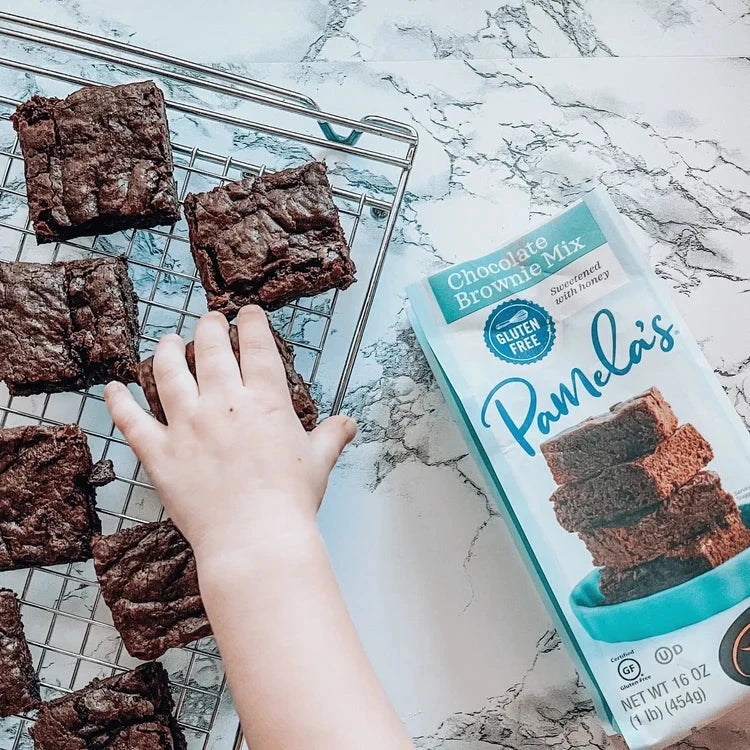 Gluten-free chocolate brownie mix from Pamela's Products, with a kid reaching for freshly baked brownies in the bundle.